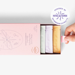 Slightly opened adaptogenic coffee selection box showing three single serve sachets: Mojo, Zen and Flow. A hand pull the box open. In the top right corner is a sticker that reads: Powered by Hifas da Terra mushroom extracts.