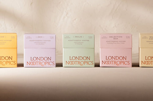 12 Sachet boxes of London Nootropics Adaptogenic boxes. From left to right: Flow blend in an orange box, Zen blend in a purple box, Mojo blend in a mint green box, a pink selection all three blends and a yellow box featuring Flow and Mojo coffee. All boxes are closed and placed on a white backdrop.