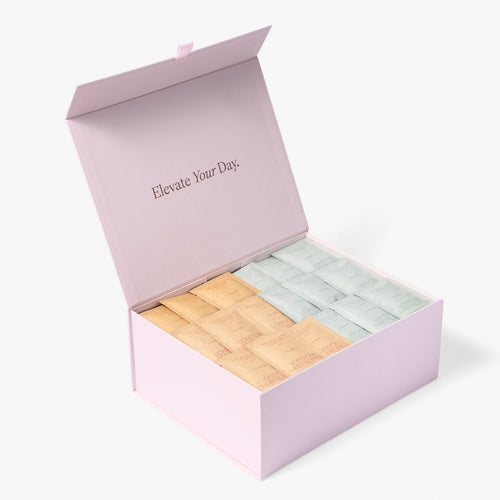 Open pink London Nootropics coffee box full of Flow (orange with pink logo) and Mojo (mint green with darker green logo) adaptogen coffee sachets